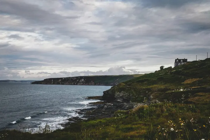 Rocky headland under a cloudy sky with the sea beyond