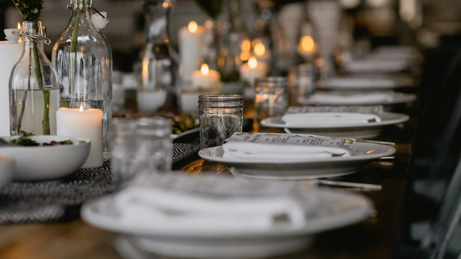 Candlelit supper club table with plates and glasses