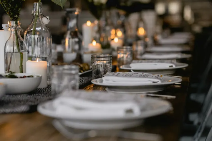 Candlelit supper club table with plates and glasses