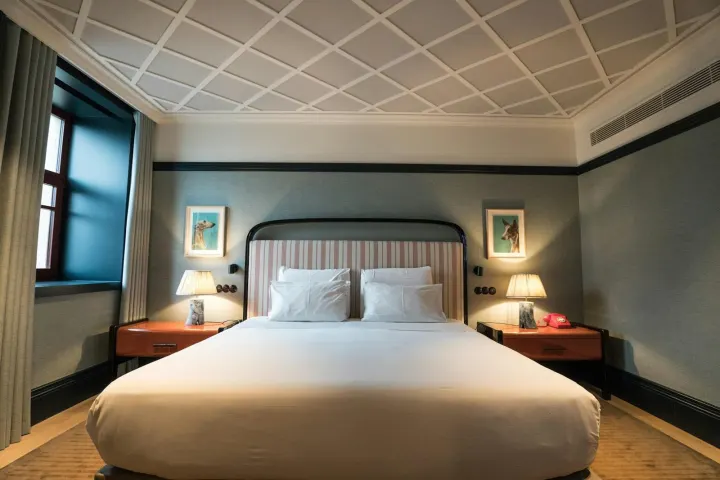 King-size bed in a room with dark green walls and a curved headboard