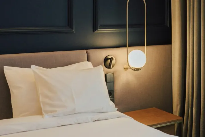 Cosy room with a white bed, a globe lamp and warm wooden panelling