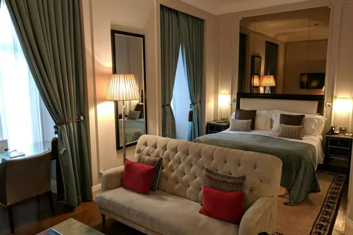 Suite with a sofa at the foot of the bed and long curtains