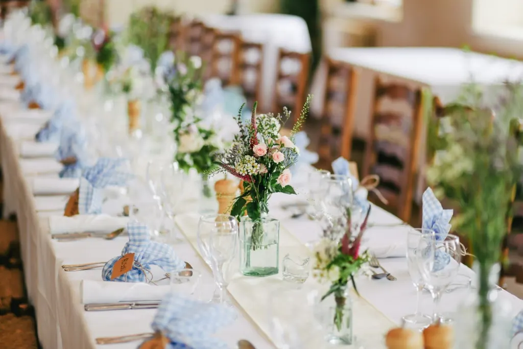 Long wedding table set with flowers and blue napkins